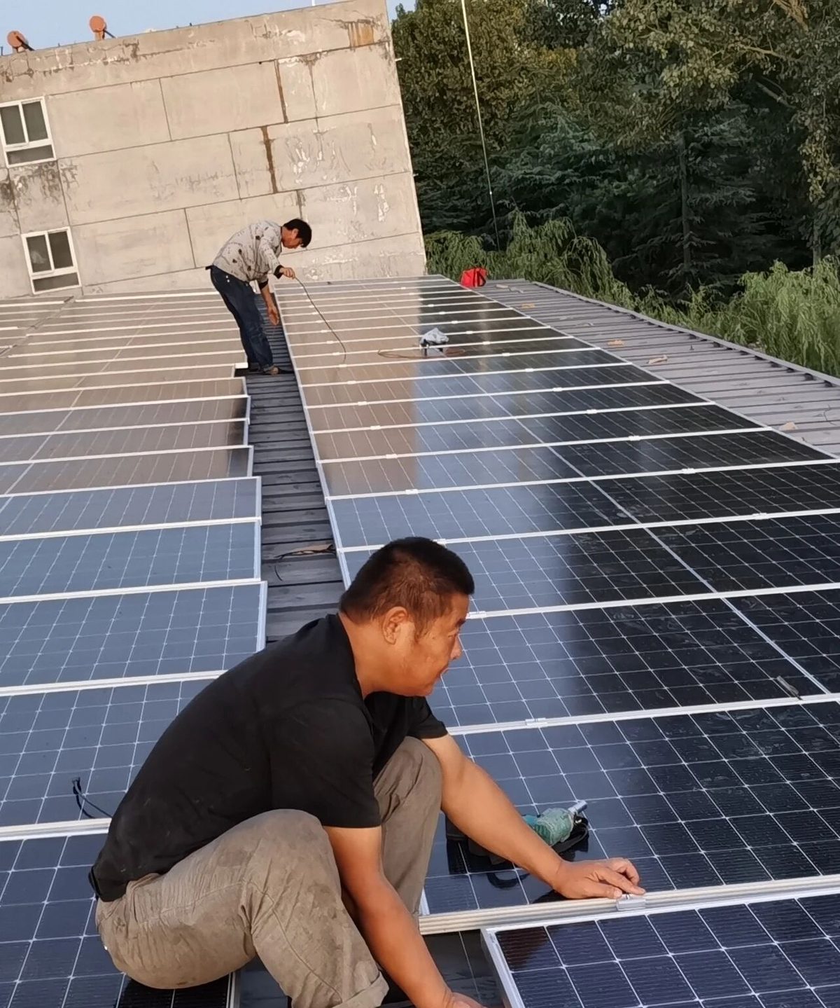 Dos instaladores fijando módulos en una cubierta metálica